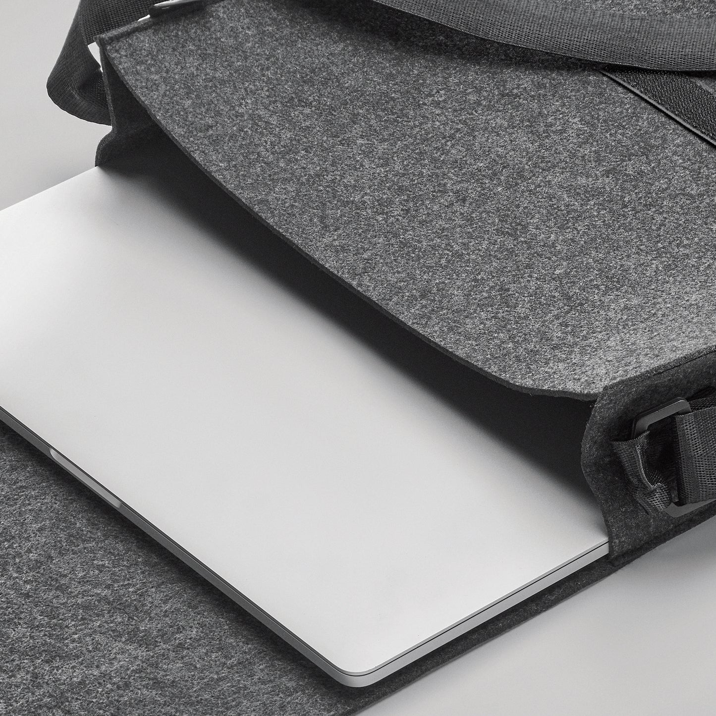 Umhängetasche aus RPET-Filz. Klettverschluss und Umhängegurt. Bietet Platz für einen 15'' Laptop.