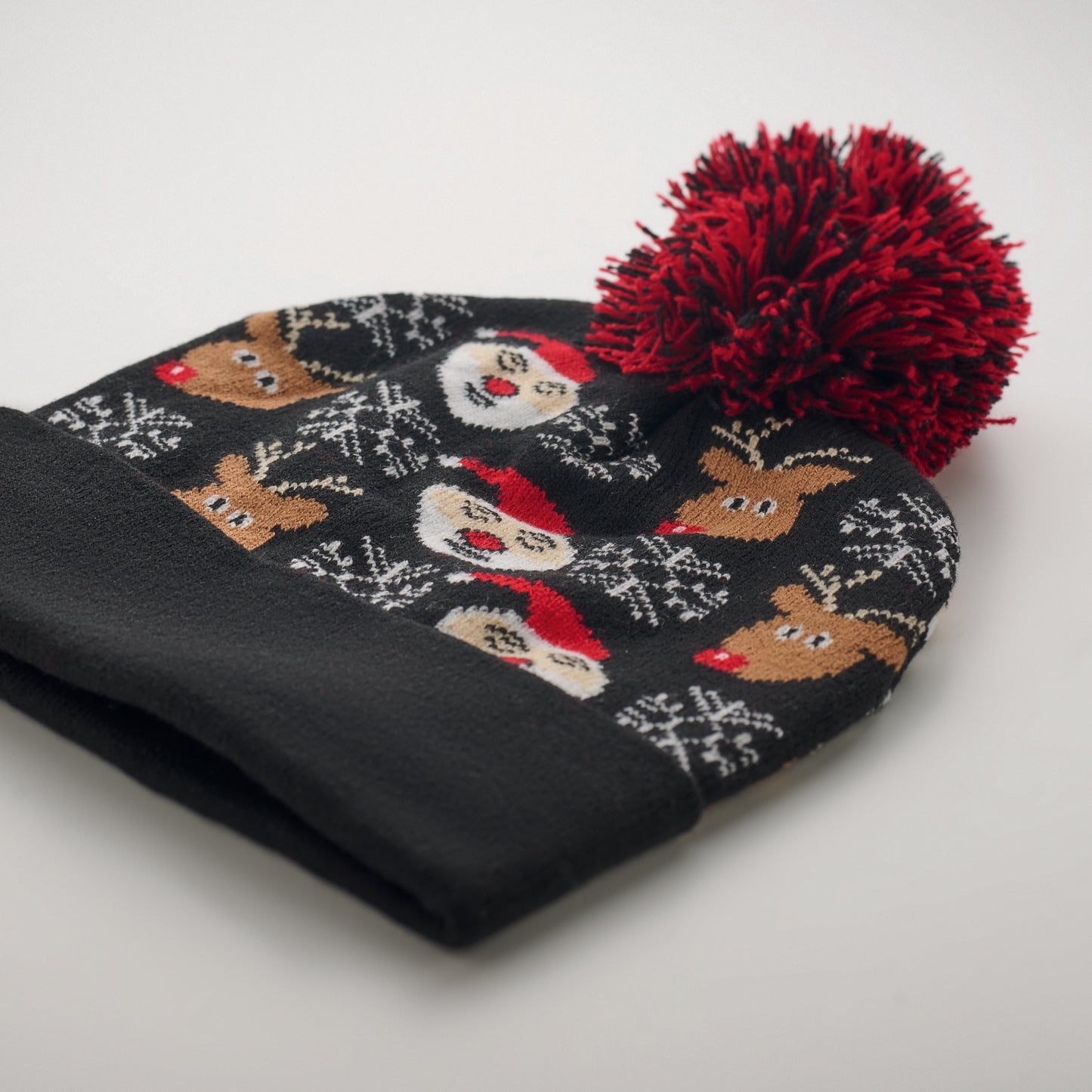 Weihnachtliche Strickmütze mit Bündchen und Bommel aus weichem elastischem Acryl.