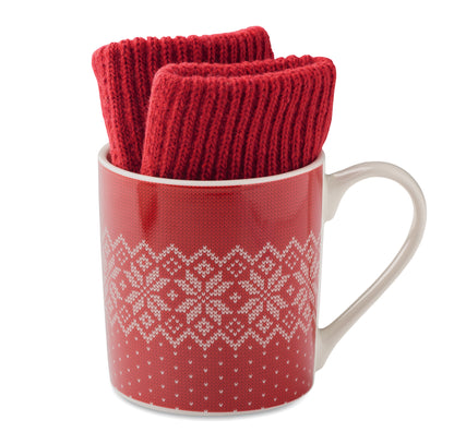 Winterliches Geschenkset bestehend aus einem Paar gestrickter taktiler Handschuhe und Keramikbecher. Schneeflockenmuster.