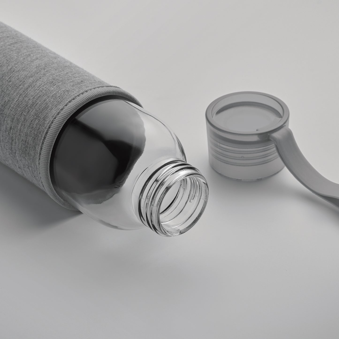 Trinkflasche aus recyceltem Glas mit Neopren-Schutzhülle und PP-Deckel mit Silikon-Schlaufe. Auslaufsicher. Füllmenge: