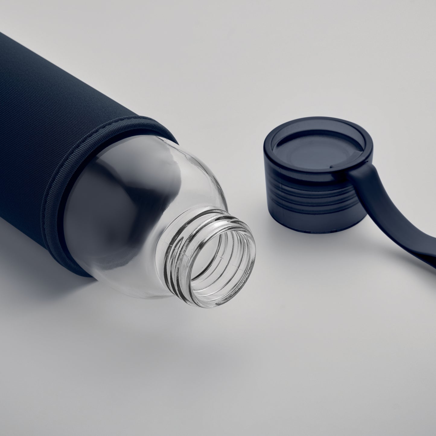 Trinkflasche aus recyceltem Glas mit Neopren-Schutzhülle und PP-Deckel mit Silikon-Schlaufe. Auslaufsicher. Füllmenge: