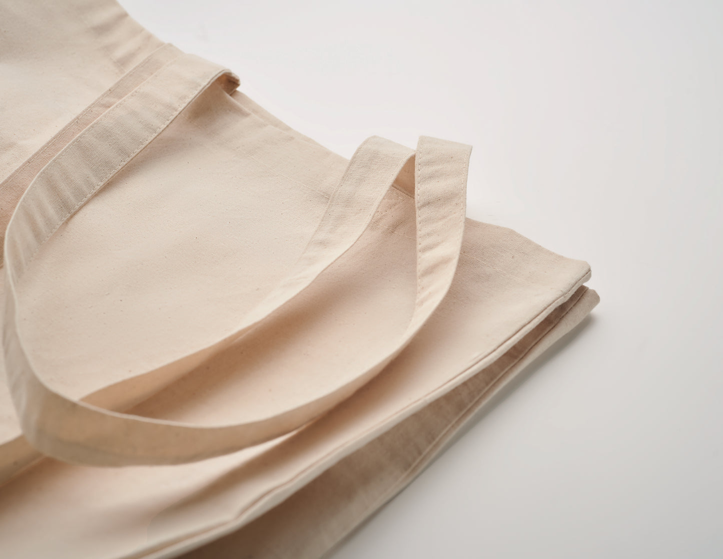 Einkaufstasche aus Fairtrade-Baumwolle. Lange Tragegriffe und seitliche Falz. 180 g/m².