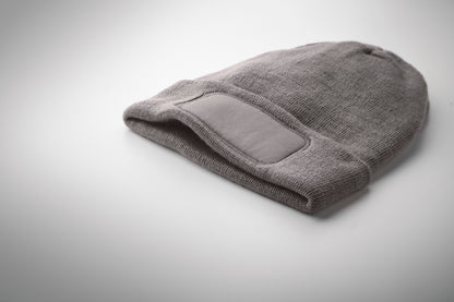 Beanie aus softem elastischem RPET-Polyester. Mit Umschlag und Aufnäher. Unisex.