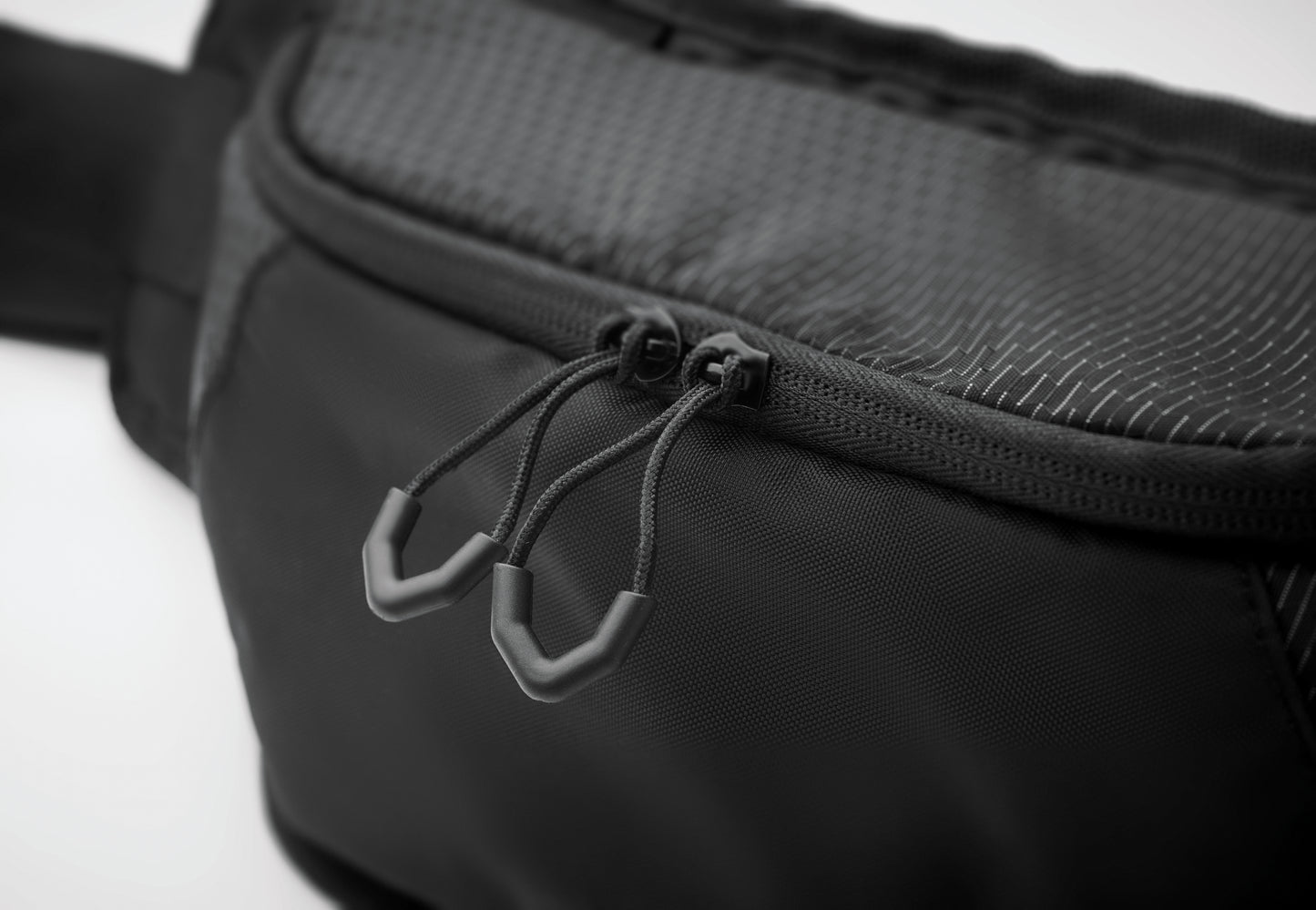 Gürteltasche aus wasserabweisendem 420D-Nylon mit 210D-Polyesterfutter. Reflektierender Streifen. Komplett gepolstertes Hauptfach. Große