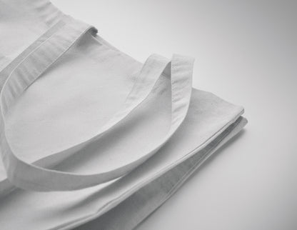 Einkaufstasche aus Fairtrade-Baumwolle mit langen Tragegriffen und Bodenfalz. 180 g/m².