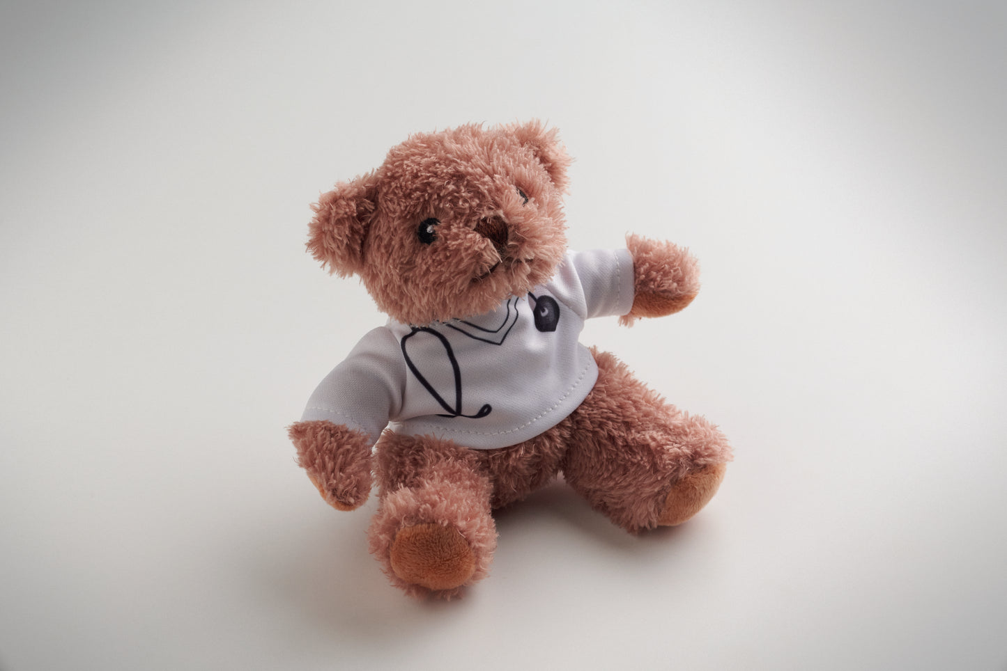 Teddybär aus Polyester gekleidet als Arzt mit bedrucktem weißem T-Shirt. Augen Nase
