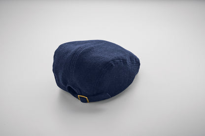 Flache Newsboy-Kappe aus meliertem 335 g/m² Polyester mit Metallverschluss.