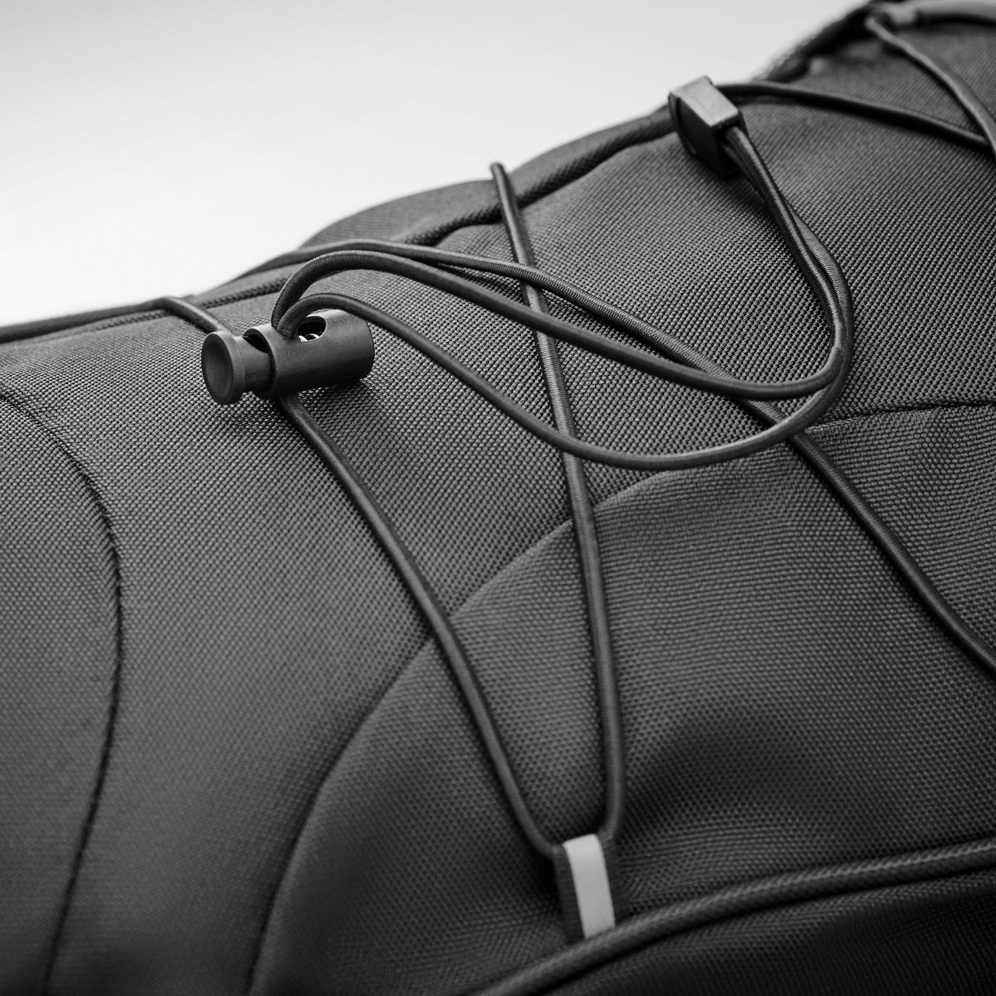 Rucksack aus 600D RPET mit Schnürung auf der Vorderseite und reflektierenden Details.