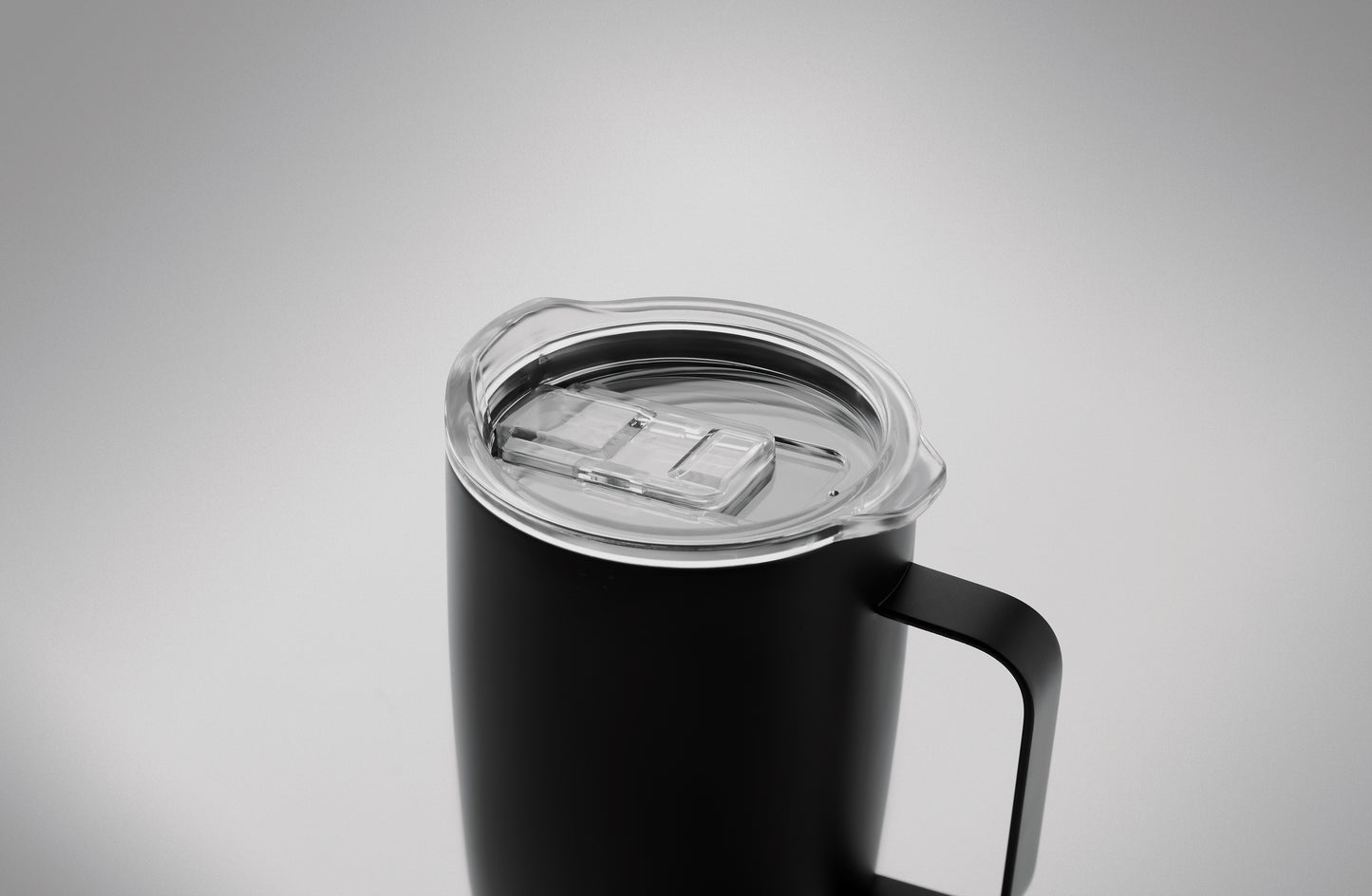Becher aus doppelwandigem Edelstahl. Der Boden ist mit Kork abgesetzt. Schiebedeckel mit